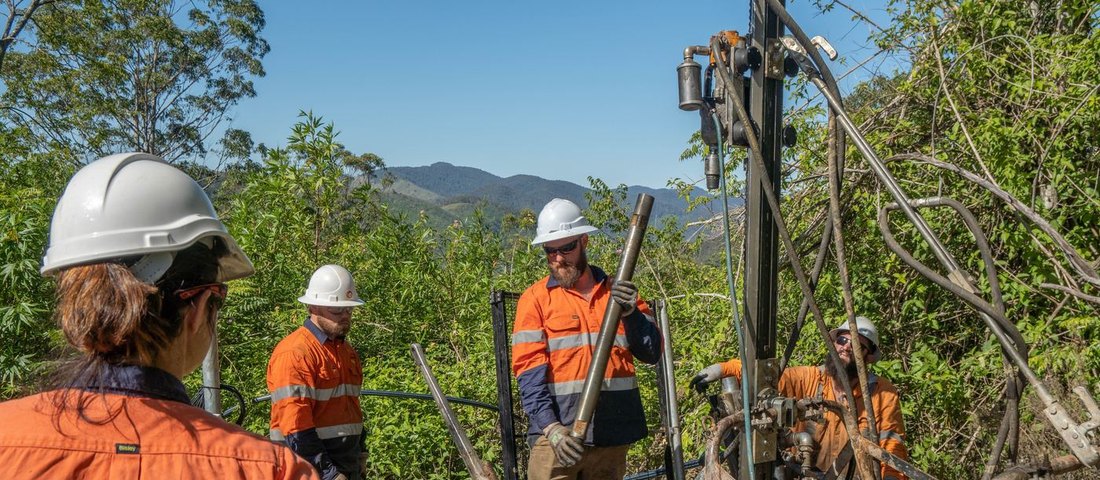 Investigation drilling crew handling core rod at a remote rig