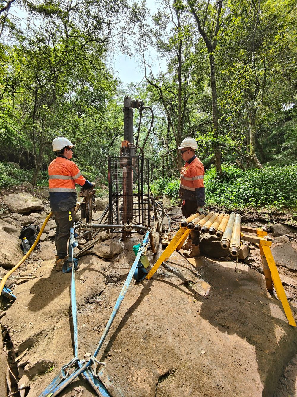 Man portable drill rig set up on rocky ground