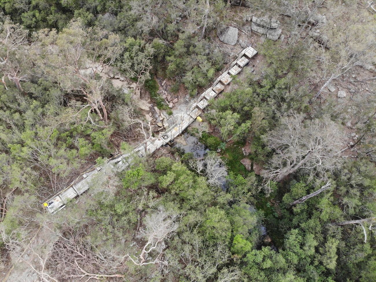 Aerial view of a scaffold platform across a forested creek